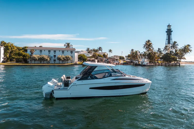 Slide: The Image of Aquila 32 Sport 2022 boat cruising near a lighthouse and palm trees. - 51
