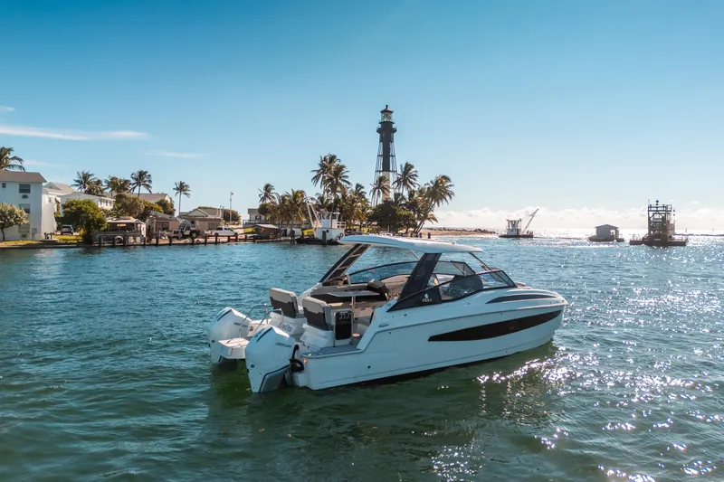 Slide: The Image of Aquila 32 Sport 2022 boat cruising near a scenic lighthouse and palm trees. - 54