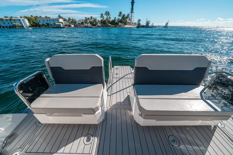 Slide: The Image of Aquila 32 Sport 2022 boat deck with seating, ocean view, and distant lighthouse. - 7