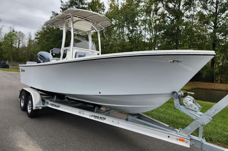 Slide: The Image of 2026 May-Craft 238 CC boat on trailer, parked outdoors near trees. - 1