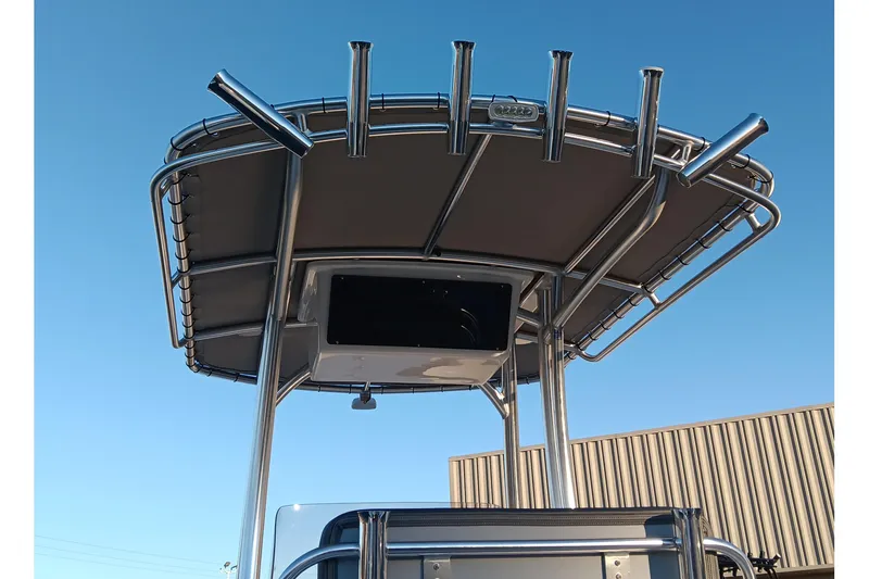 Slide: The Image of 2026 May-Craft 238 CC boat with T-top and rod holders against clear sky. - 14