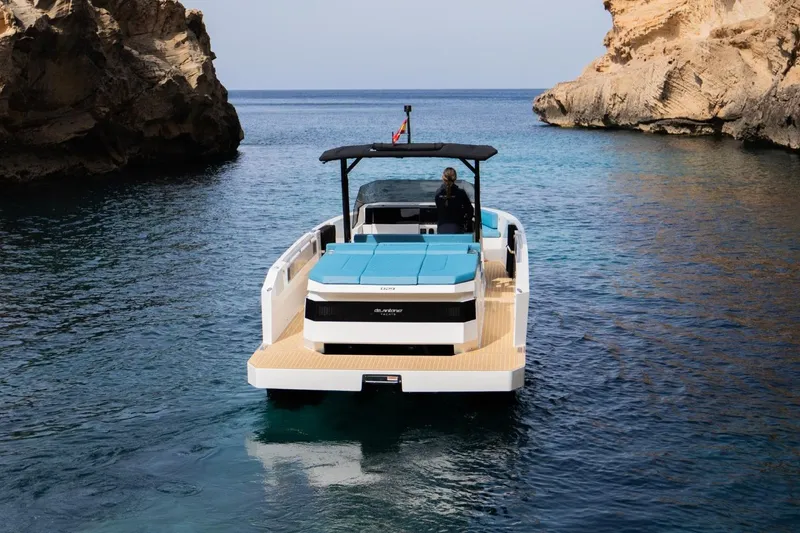 Slide: The Image of 2026 De Antonio Yachts D29 cruising in a serene rocky cove. - 4