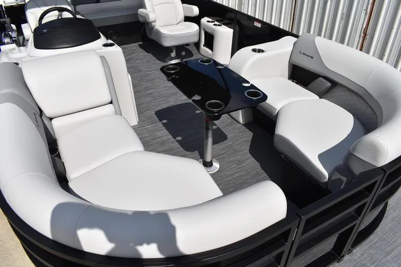 Slide: The Image of 2023 Lowe SS 230 DV pontoon boat interior with white seating and black table. - 14