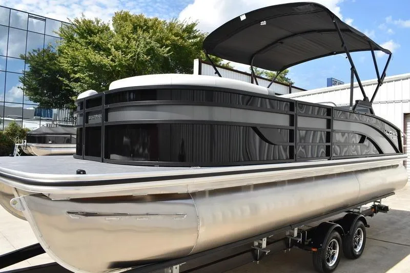 Slide: The Image of 2023 Lowe SS 230 DV pontoon boat with canopy, parked on a trailer. - 7