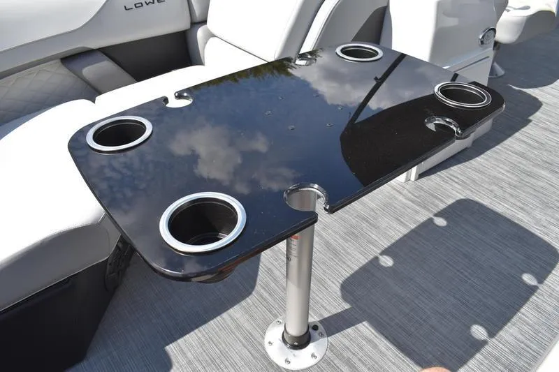 Slide: The Image of 2023 Lowe SS 230 DV boat interior with sleek black table and cup holders. - 11