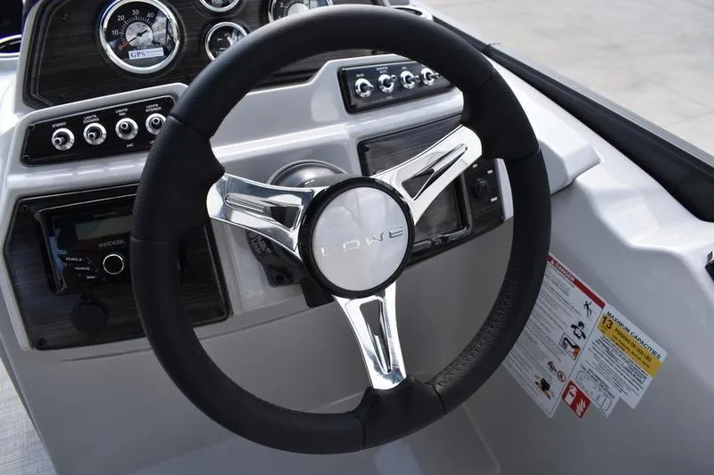 Slide: The Image of Steering wheel of 2023 Lowe SS 230 DV boat with dashboard controls. - 29