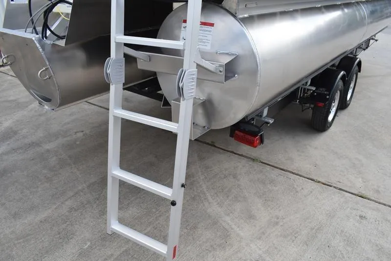 Slide: The Image of 2023 Lowe SS 230 DV pontoon boat with ladder and trailer on concrete surface. - 8