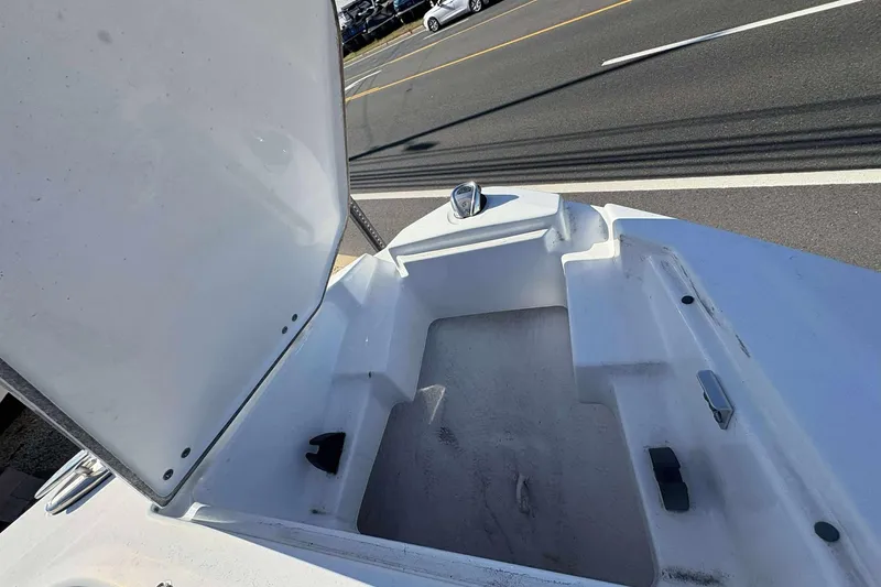 Slide: The Image of 2023 Monterey 238SS Super Sport boat storage compartment open on a sunny day. - 9