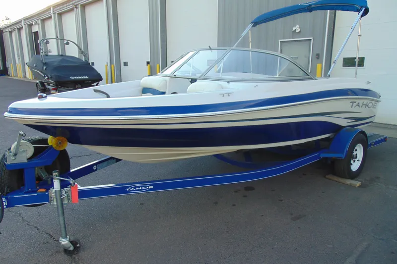 The Image of 2007 Tahoe Q4 I/O Sport boat on trailer, parked outside a storage facility. - 1