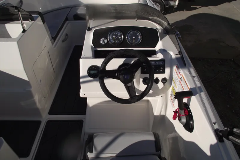 Slide: The Image of 2026 Bayliner M19 boat cockpit with steering wheel and control panel. - 14
