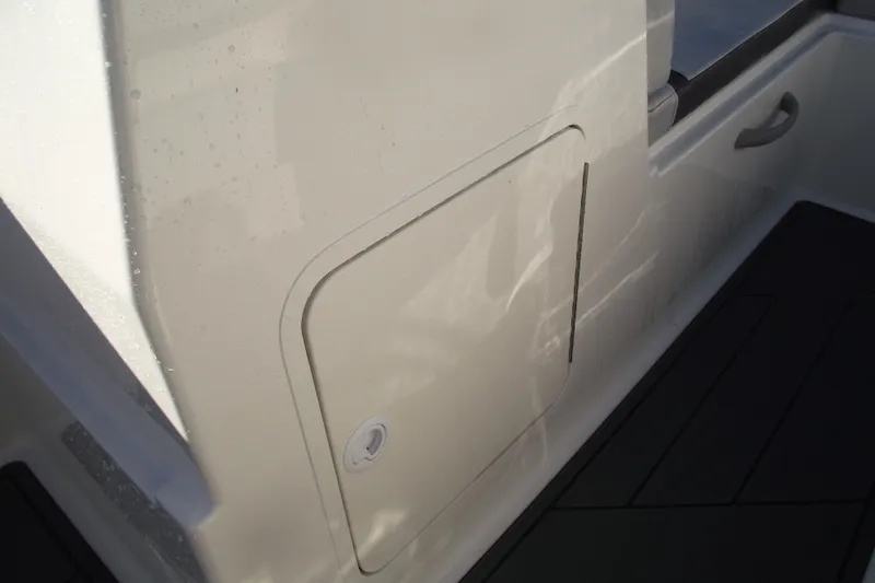 Slide: The Image of 2026 Bayliner M19 boat interior storage compartment with handle and sleek design. - 17
