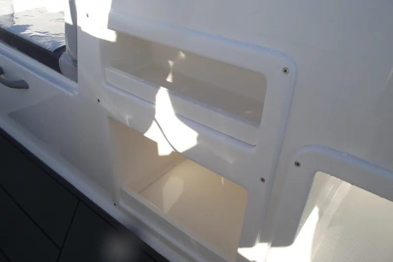 Slide: The Image of 2026 Bayliner M19 boat interior storage compartments in white, showcasing sleek design. - 19