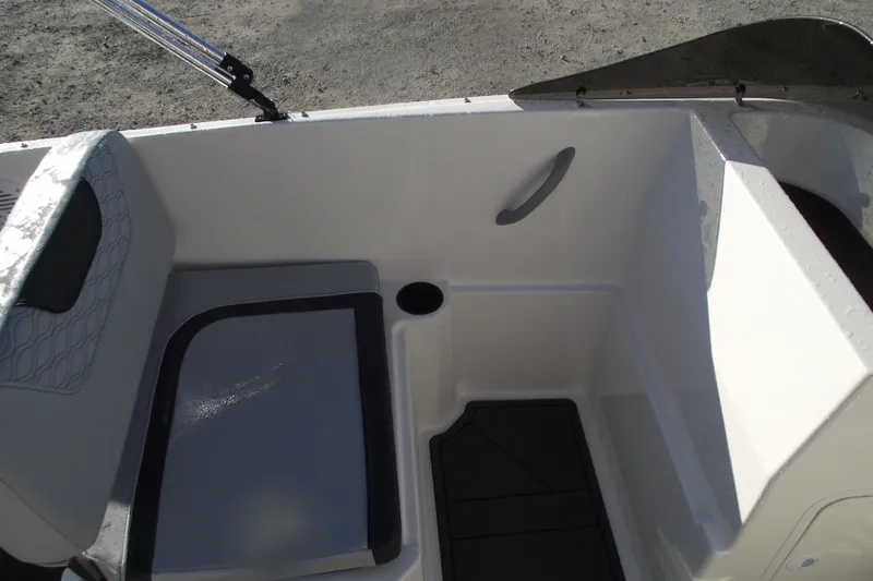 Slide: The Image of Interior view of 2026 Bayliner M19 boat, featuring seating and storage area. - 20