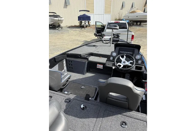 Slide: The Image of 2024 Nitro Z19 boat interior with steering wheel and seating, parked near other boats. - 10