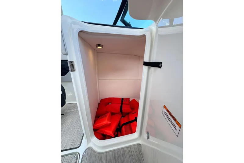 Slide: The Image of Storage compartment with life jackets in 2021 Sea Ray SPX 230 Outboard boat. - 12