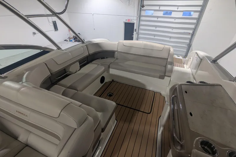 Slide: The Image of 2014 Formula 350 Crossover Bowrider interior with beige seating and wood flooring. - 14