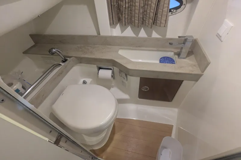 Slide: The Image of 2014 Formula 350 Crossover Bowrider bathroom with toilet, sink, and wooden flooring. - 25
