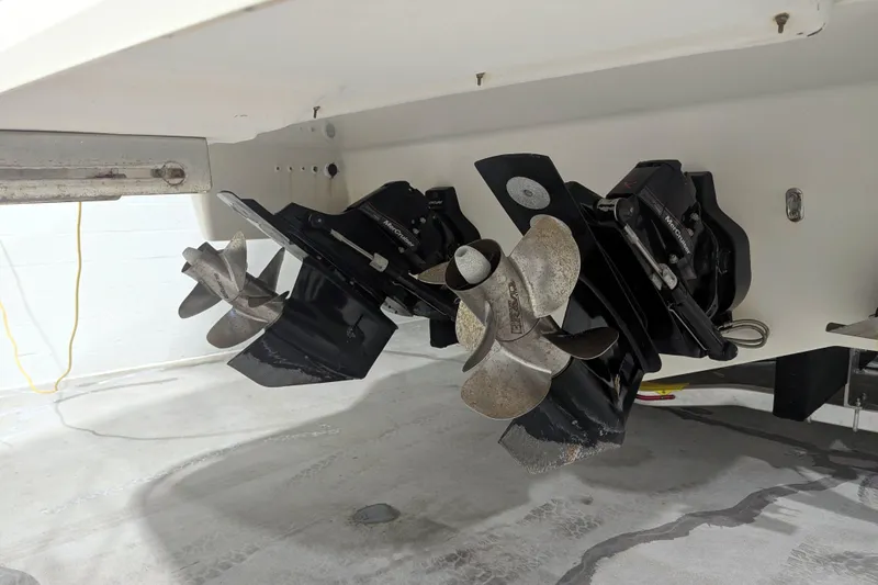 Slide: The Image of 2014 Formula 350 Crossover Bowrider boat propellers and outdrives in a garage. - 45