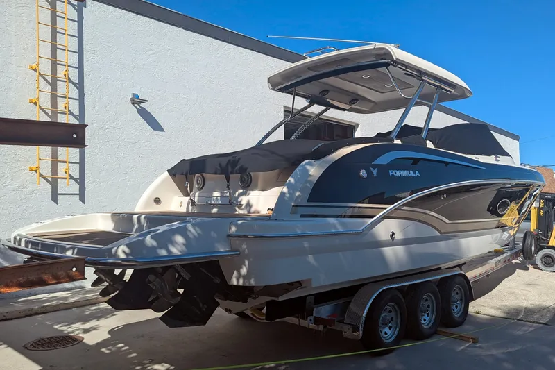 Slide: The Image of 2014 Formula 350 Crossover Bowrider on trailer, parked outdoors under clear blue sky. - 49