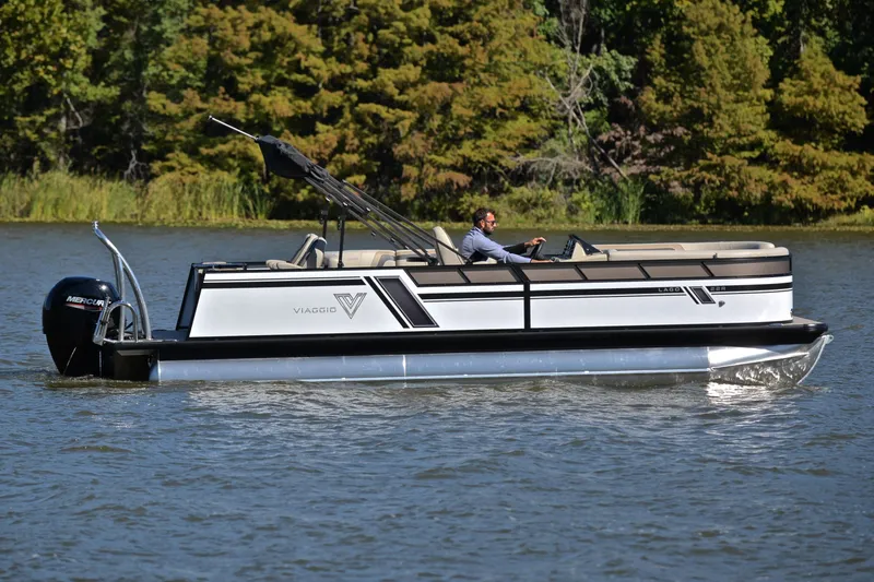 Slide: The Image of 2023 Viaggio Lago 22 R pontoon boat cruising on a lake with lush greenery. - 6