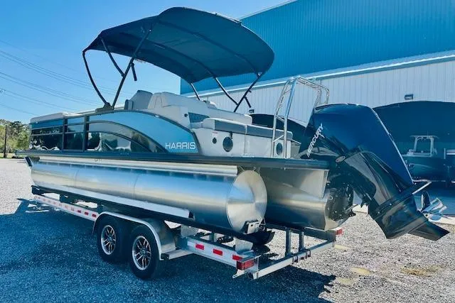 Slide: The Image of 2025 Harris Cruiser 250 pontoon boat on trailer, with canopy and Mercury outboard motor. - 3