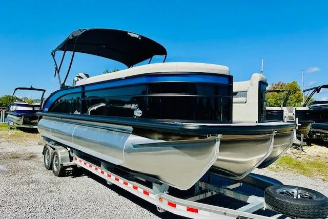 Slide: The Image of 2025 Harris Cruiser 250 pontoon boat on trailer under clear blue sky. - 7