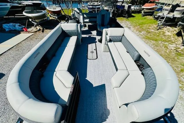 Slide: The Image of 2025 Harris Cruiser 250 pontoon boat with spacious seating, docked outdoors. - 8