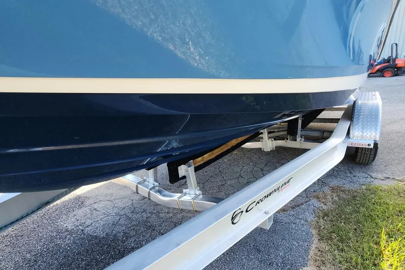 Slide: The Image of 2021 Sea Ray SPX 230 Outboard on trailer, blue hull, parked on pavement. - 19