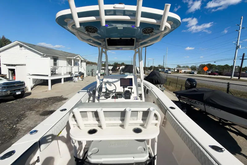 Slide: The Image of 2026 Sea Chaser 24 HFC DE boat with modern console and seating, parked outdoors. - 25