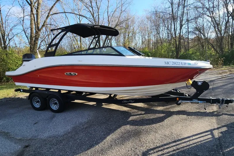 Slide: The Image of 2021 Sea Ray SPX 230 Outboard boat on trailer, red and white design, parked outdoors. - 32
