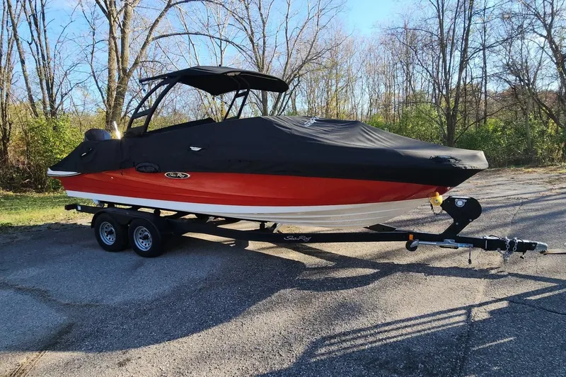 Slide: The Image of 2021 Sea Ray SPX 230 Outboard boat on trailer, covered, in a wooded area. - 33
