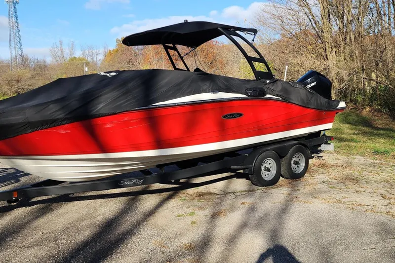 Slide: The Image of 2021 Sea Ray SPX 230 Outboard boat, red with black cover, on a trailer. - 34