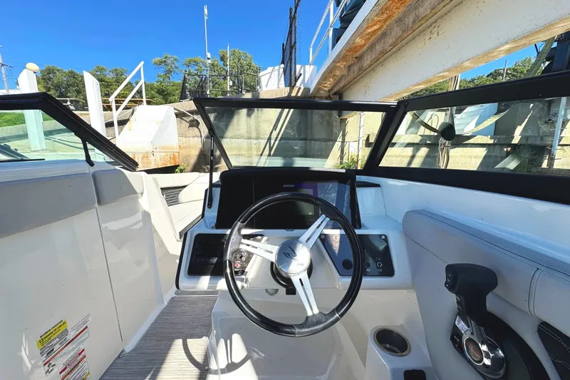Slide: The Image of 2021 Sea Ray SPX 230 Outboard boat interior with steering wheel and dashboard controls. - 5