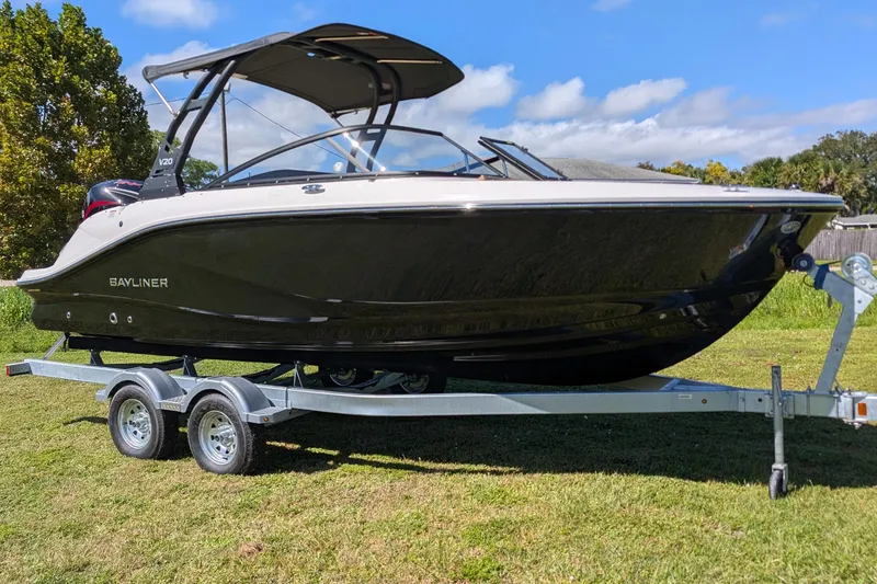 The Image of 2026 Bayliner V20 boat on trailer, parked on grass under a clear sky. - 1
