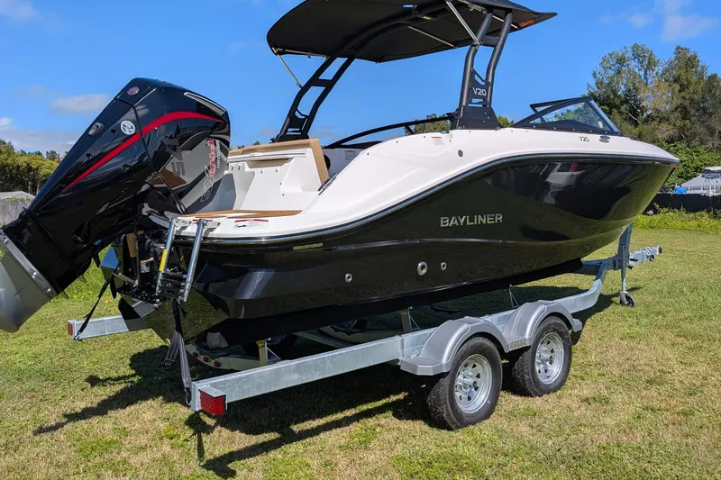 Slide: The Image of 2026 Bayliner V20 boat on trailer, black and white design, parked on grass. - 3