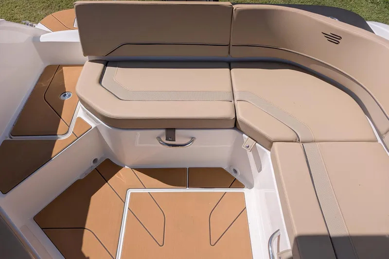 Slide: The Image of 2026 Bayliner V20 boat interior with beige cushioned seating and teak-style flooring. - 7