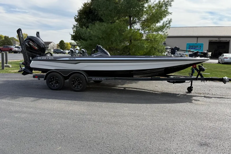 The Image of 2026 Skeeter ZXE21 boat on trailer, parked outdoors near trees and buildings. - 1