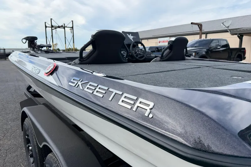 Slide: The Image of 2026 Skeeter ZXE21 boat, sleek design, parked outdoors, showcasing brand logo. - 15
