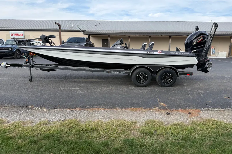 Slide: The Image of 2026 Skeeter ZXE21 boat on trailer, parked outdoors near Yamaha building. - 5