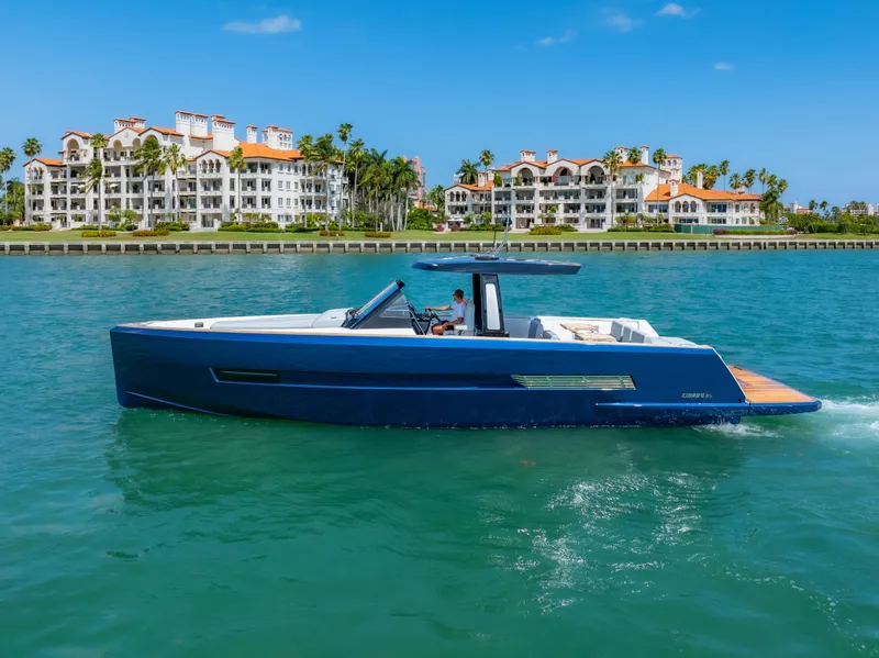 The Image of 2022 Fjord 44 Open yacht cruising near luxury waterfront residences. - 0