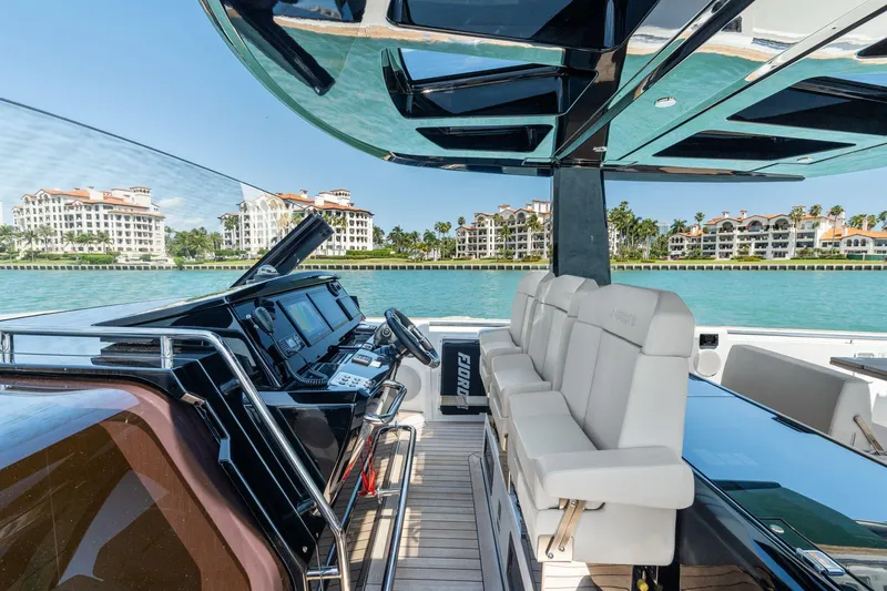 Slide: The Image of 2022 Fjord 44 Open yacht interior with luxurious seating and modern controls, overlooking waterfront buildings. - 2