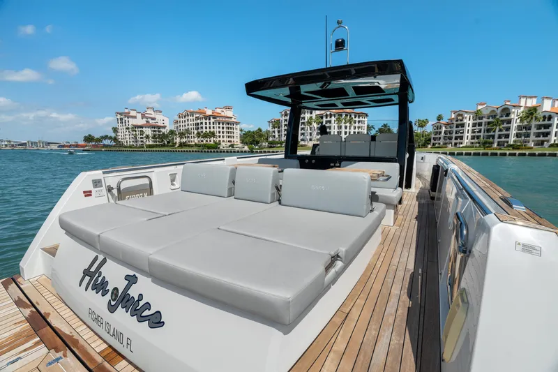 Slide: The Image of 2022 Fjord 44 Open yacht with sunbathing area, docked near luxury waterfront residences. - 32