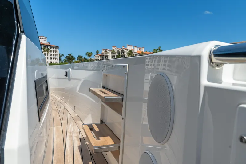 Slide: The Image of Fjord 44 Open 2022 yacht deck with wooden steps and speakers, under clear blue sky. - 34