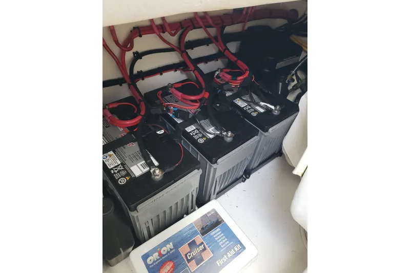 Slide: The Image of Batteries and wiring inside a 2022 Albury Brothers 27 boat, with a first aid kit nearby. - 16