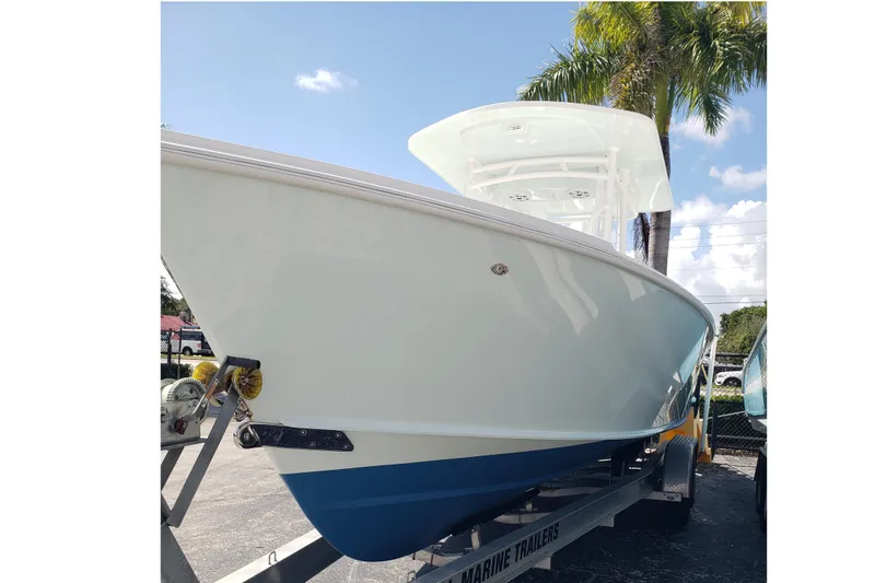 Slide: The Image of 2022 Albury Brothers 27 boat on trailer under palm trees, clear sky background. - 4