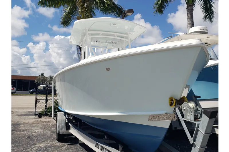 Slide: The Image of 2022 Albury Brothers 27 boat on trailer, under palm trees, clear sky background. - 5
