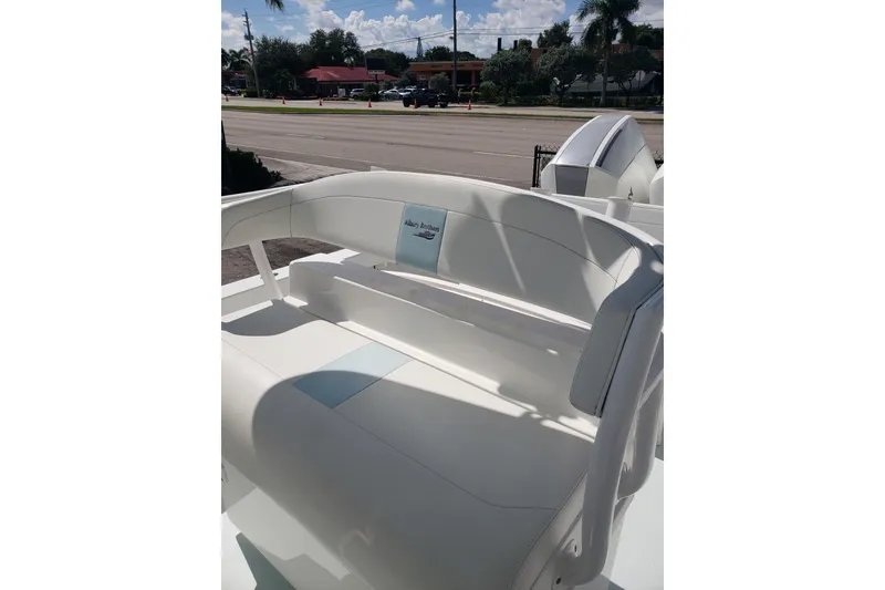 Slide: The Image of 2022 Albury Brothers 27 boat interior with white seating, parked near a road. - 8