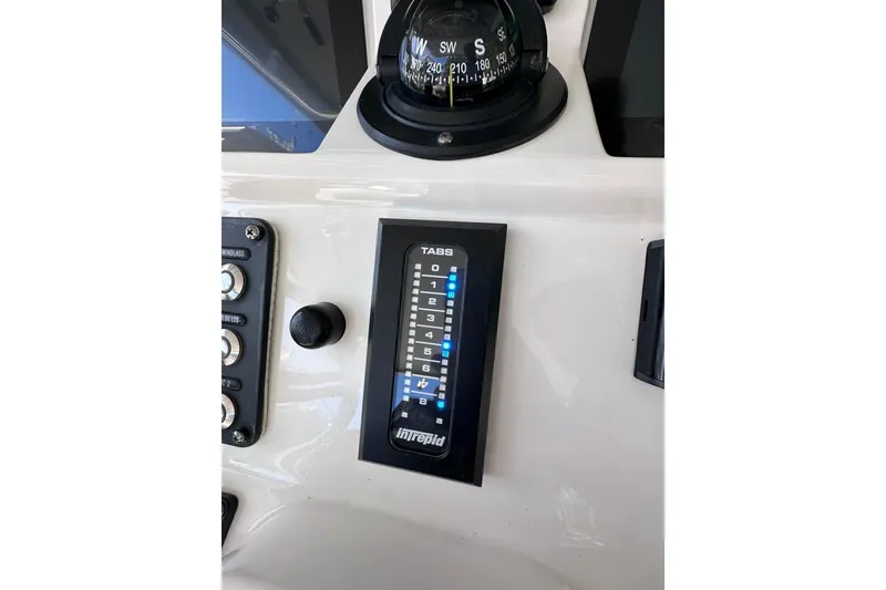 Slide: The Image of Control panel of 2020 Intrepid 409 Valor boat with compass and tab settings. - 21