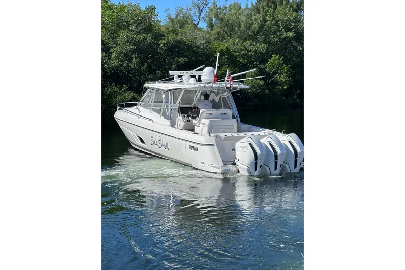 Slide: The Image of 2020 Intrepid 409 Valor boat cruising on a calm waterway, surrounded by lush greenery. - 4