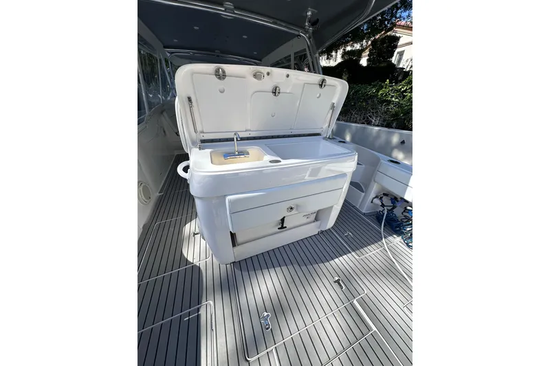 Slide: The Image of 2020 Intrepid 409 Valor boat interior with open storage compartment and sink. - 52